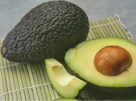 A plate with slices of avocado showcases its rich green color and smooth, creamy texture.