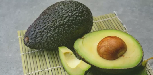 A plate with slices of avocado showcases its rich green color and smooth, creamy texture.