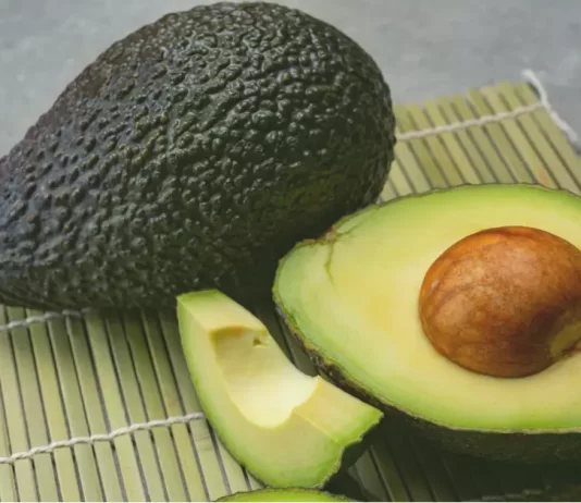 A plate with slices of avocado showcases its rich green color and smooth, creamy texture.