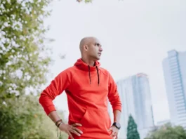 A person jogging in a park signifies exercise for belly fat reduction.
