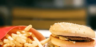 While ordering fast food, a person makes a mindful choice, focusing on health and budget-conscious decisions.