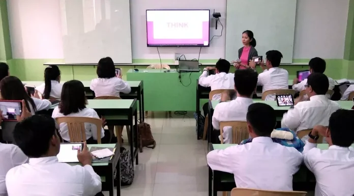 Classroom scene showing teachers interacting with students in a K-12 setting in the Philippines.