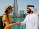A tourist and an Emirati man greeting with a handshake in Dubai