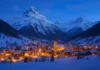Scenic snowy mountain village illuminated with winter lights, representing the best countries to visit in winter.