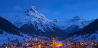 Scenic snowy mountain village illuminated with winter lights, representing the best countries to visit in winter.