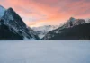 Snow-covered mountains and frozen Lake Louise in Banff National Park during winter.