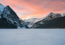 Snow-covered mountains and frozen Lake Louise in Banff National Park during winter.