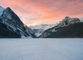 Snow-covered mountains and frozen Lake Louise in Banff National Park during winter.