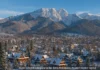 Zakopane in winter with snowy mountains, ski slopes, and wooden chalets in Poland.