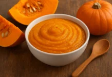 Why Every Parent Should Add Pumpkin to Their Child’s Diet Pumpkin puree in a bowl with slices of pumpkin and spoon on a wooden table